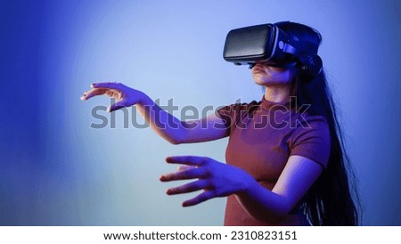Young Asian Indian woman wearing virtual reality headset, girl with vr glasses concept studio portrait