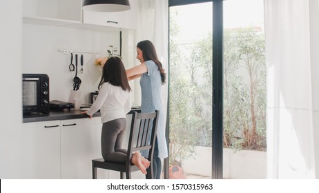 Young Asian Japanese Mom And Daughter Cooking At Home. Lifestyle Women Happy Making Pasta And Spaghetti Together For Breakfast Meal In Modern Kitchen At House In The Morning Concept.