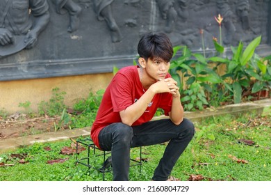 Young Asian Jealous Boy In Red T-shirt Watching Someone- Palembang, Indonesia 26 May 2022.