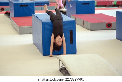 Young asian kid Gymnast Doing Handstand with gym tool on gym room to practice body Balance  - Powered by Shutterstock