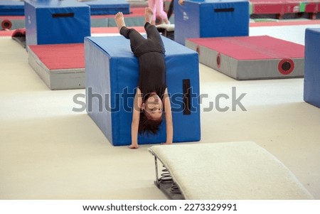 Young asian kid Gymnast Doing Handstand with gym tool on gym room to practice body Balance 