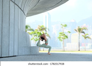 Young Asian Lady Female Yogi Performing Yoga Pose At A Park In Kowloon, Hong Kong, On A Sunny Day.