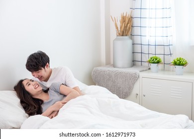 Young Asian Lover Couple Laying And Hugging On Bed In Bedroom.