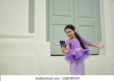 Young Asian Or Malay Girl In Lace And Tulle Peplum Taking Selfie.