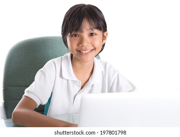 Young Asian Malay Girl Sitting At Her Desk With A Laptop Over White Background