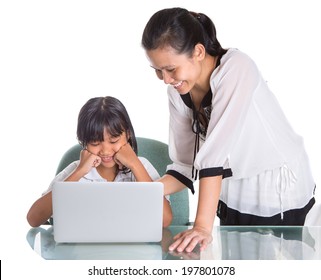 Young Asian Malay School Girl Studying With Her Laptop With A Female Teacher Observing