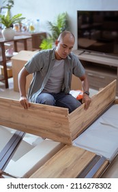 Young Asian Male Assembling Furniture By Himself