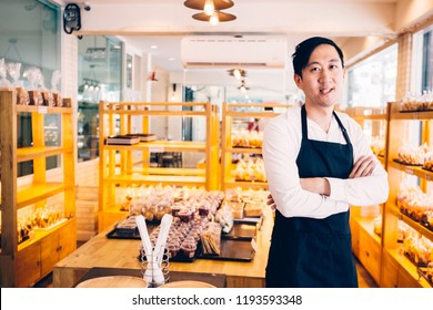 Young Asian Male Bakery Shop Merchant Business Owner Smiling And Looking At The Camera In Bread Store