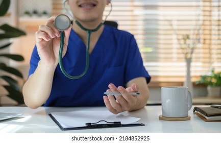 Young Asian Male Doctor Or Nurse Holding Stethoscope In Hand. Cardiology Medical Clinic, Cardiac Treatment Concept.