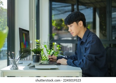 Young asian male graphic designer working  with color swatch samples at modern office. - Powered by Shutterstock