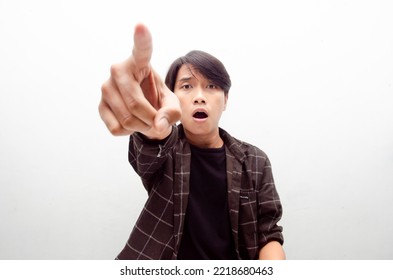 Young Asian Male Millenial Worker Or Student Wearing Black Tshirt Isolated Over White Background Angry, Mad, Frustrated. Man Pointing To Camera Angrily.