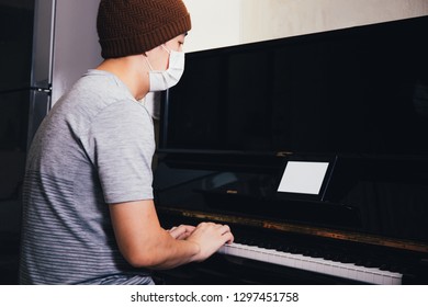 Young Asian Male Patient With Sickness Playing Piano While Using An Empty Copy Space Tablet Screen At Home - Telecommunication Healthcare  And Music Therapy Concept