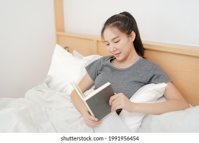 Young Asian Male Reading A Book At Home, Relaxation Concept.