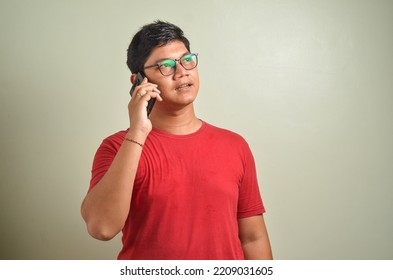 Young Asian Man Answering Phone Call With Happy Expression