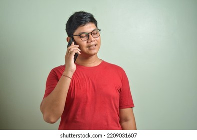 Young Asian Man Answering Phone Call With Happy Expression