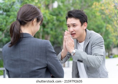 Young Asian Man Apologizing To Woman