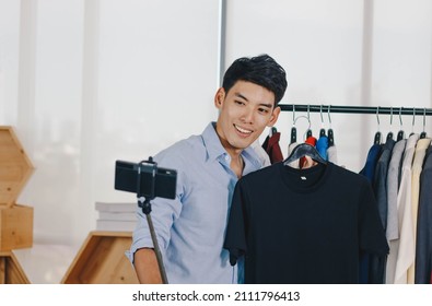 Young Asian Man Blogger Is Broadcasting A Video For Selling Clothes Online.