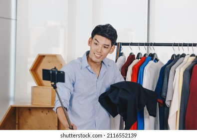 Young Asian Man Blogger Is Broadcasting A Video For Selling Clothes Online.