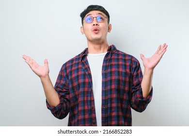 Young Asian Man Celebrating Crazy And Amazed For Success With Arms Raised And Open Eyes Screaming Excited Over White Background. Winner Concept