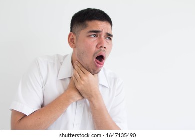 Young Asian Man Chocked With Tongue Out Against White Background, Want To Puke Gesture