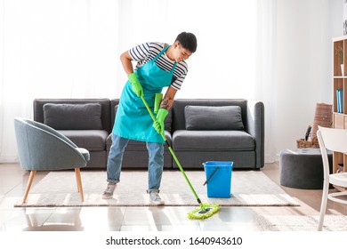 Young Asian Man Cleaning Floor At Home