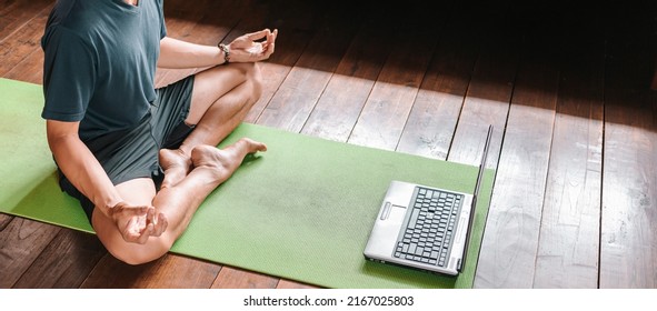 Young Asian Man  Coach Internet Video Online Training Yoga Instructor Modern Laptop Screen Meditate Sukhasana Posture Relax Breathe Easy Seat Pose Gym Healthy Lifestyle At Home Concept.