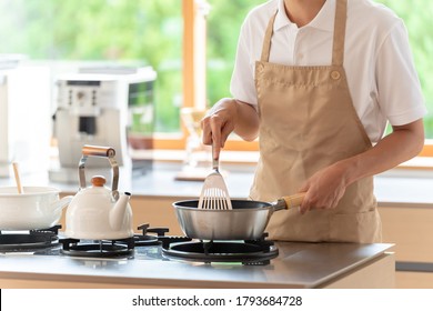 Young Asian Man Cooking At Kitchen