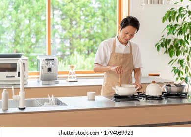 Young Asian Man Cooking At Kitchen