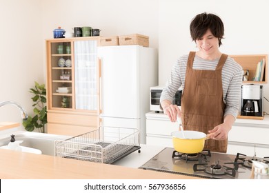 Young Asian Man Cooking In The Kitchen