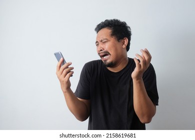 Young Asian Man Crying While Holding Phone