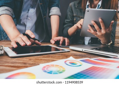 Young asian man designer using graphics tablet while working with computer at studio or office,Graphic design and color swatches and pens on a desk warm colours sun light. - Powered by Shutterstock