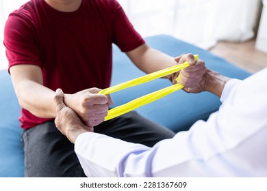 Young Asian man doing physiotherapy and seeking advice from muscle pain with shoulder, limbs in rehabilitation center. - Powered by Shutterstock