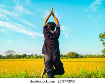 Young Asian Man Doing Yoga Exercise For Healthy Life. Asian Man Meditating With Peaceful Nature In The Morning 