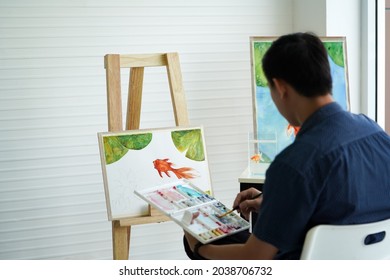 Young Asian Man Drawing A Goldfish And Lotus Leaf On White Board In Watercolor Painting Art Classes