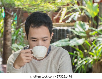 Young Asian Man Is Drinking Coffee In Cafe