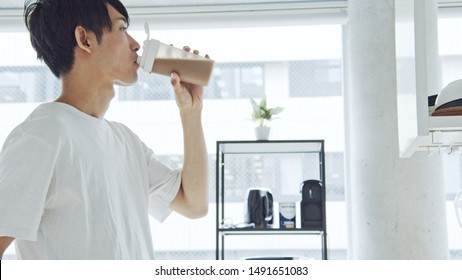 Young Asian Man Drinking Protein Drink.