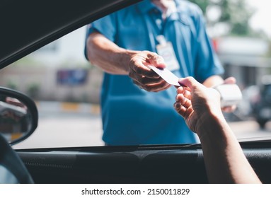 Young Asian  man driving car hand holding credit card payment for gasoline at petrol station. Traveler man car owner paying fuel pump with credit card, customer mileage point loyalty reward concept. - Shutterstock ID 2150011829