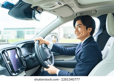 Young Asian man driving a car. - Powered by Shutterstock