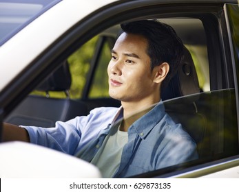 Young Asian Man Driving A Car, Happy And Smiling.