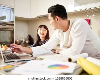 Young Asian Man Free Lance Designer Father Working At Home While Taking Care Of Daughter.