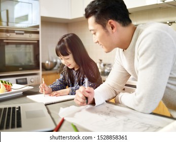 Young Asian Man Free Lance Designer Father Working At Home While Taking Care Of Daughter.