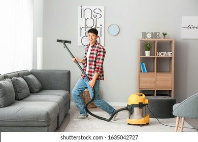 Young Asian Man Having Fun While Cleaning Floor At Home