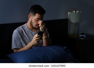 Young Asian Man Having Sore And Tired Eyes When Using Smartphone While Lying In Bed At Night. Young Man Cannot Sleep From Insomnia	