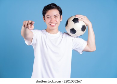 Young Asian man holding ball on background - Powered by Shutterstock