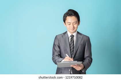 Young Asian Man Holding A Clip Board.