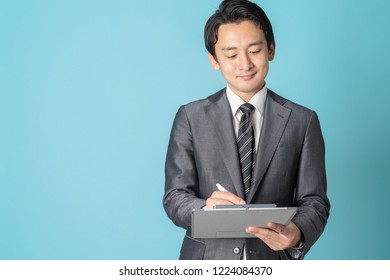 Young Asian Man Holding A Clip Board.