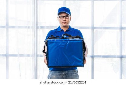 Young Asian Man Holding Food Bag And Standing Inside Of The Studio, Delivery Box Concept.