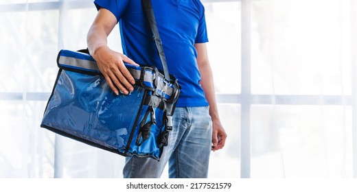 Young Asian Man Holding Food Bag And Standing Inside Of The Studio, Delivery Box Concept.