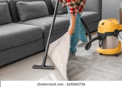 Young Asian Man Hoovering Floor At Home