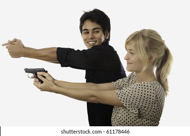 young asian man instructs a young woman about shooting an automatic pistol